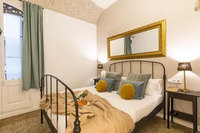 a bedroom with a bed with a mirror on the wall at Central Suites Barcelona in Barcelona