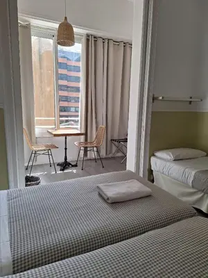 a bedroom with two beds and a table and chairs at Casa Consell Apartments in Barcelona