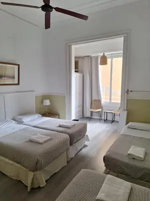a bedroom with two beds and a large window at Casa Consell Apartments in Barcelona