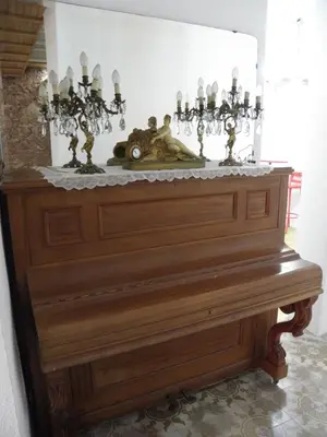 a wooden piano with a statue on top of it at Hostal Cal Pla in Sant Llorenc Savall