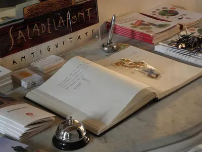 an open book sitting on a table with other books at Hostal Cal Pla in Sant Llorenc Savall