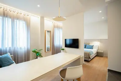 a white room with a desk and a bed at Fisa Rentals Ramblas Apartments in Barcelona