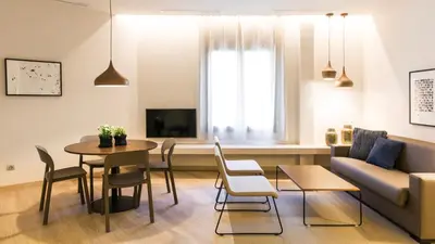 a living room with a couch and a table and chairs at Fisa Rentals Ramblas Apartments in Barcelona