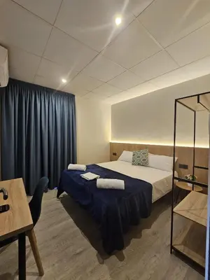 a bedroom with a bed with a blue blanket at Hotel Mar i Sol in Calella