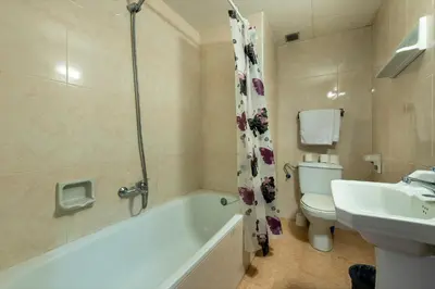 a bathroom with a tub and a toilet and a sink at Hotel Mar i Sol in Calella