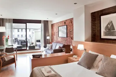 a hotel room with a bed and a living room at Wello Apartments in Barcelona
