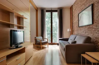 a living room with a couch and a television at Wello Apartments in Barcelona