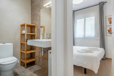 a bathroom with a bed and a sink and a toilet at Inside Barcelona Apartments Salva in Barcelona