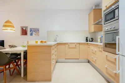 a kitchen with wooden cabinets and a dining table at Inside Barcelona Apartments Salva in Barcelona
