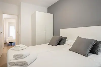 a white bed with towels on it in a room at Inside Barcelona Apartments Salva in Barcelona