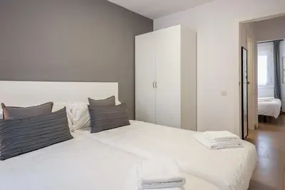 a bedroom with a large white bed with two pillows at Inside Barcelona Apartments Salva in Barcelona