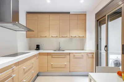 a kitchen with wooden cabinets and a sink at Inside Barcelona Apartments Salva in Barcelona