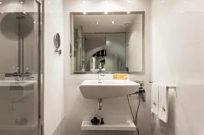 a white bathroom with a sink and a mirror at Ikonik Ramblas in Barcelona