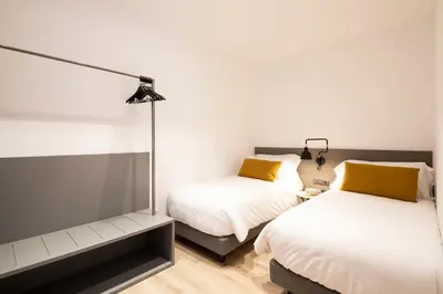 a bedroom with two beds and a mirror at Aspasios Sagrada Familia Apartments in Barcelona