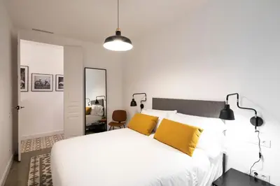 a bedroom with a white bed with yellow pillows at Aspasios Sagrada Familia Apartments in Barcelona