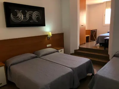 a hotel room with two beds and a staircase at Hostal Drassanes in Barcelona