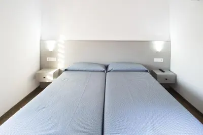 a bed in a room with two night stands at Hostal Drassanes in Barcelona