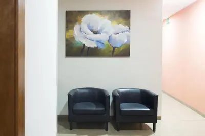 two black chairs next to a painting of a flower at Hostal Drassanes in Barcelona