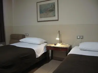 a hotel room with two beds and a lamp on a table at Hostal LK Barcelona in Barcelona