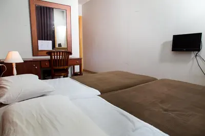 a bedroom with two beds and a desk and a television at Hostal LK Barcelona in Barcelona