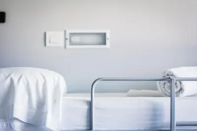a white bed with a metal frame in a bedroom at Centre Esplai Albergue in El Prat de Llobregat
