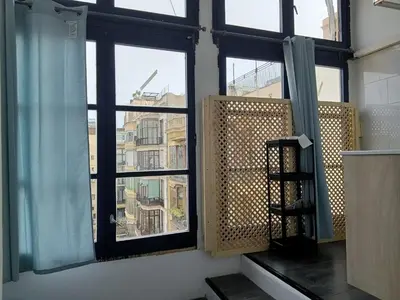a room with two windows with blue curtains at Pension Casa De Barca in Barcelona
