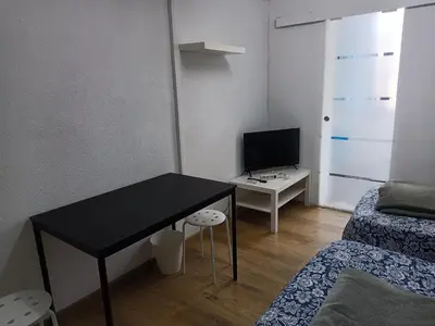 a small room with a black desk and a bed at Pension Casa De Barca in Barcelona