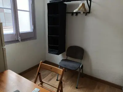 a room with a chair and a table and a window at Pension Casa De Barca in Barcelona