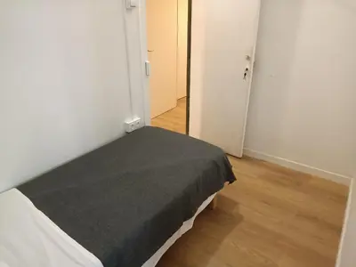 a bedroom with a bed with a gray blanket at Pension Casa De Barca in Barcelona