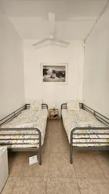 two twin beds in a room with a painting at YOUTH HOSTEL - Central and Basic Drassanes in Barcelona