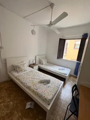two beds in a room with two windows at YOUTH HOSTEL - Central and Basic Drassanes in Barcelona