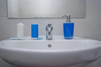 a white sink with a faucet and a blue glass at Barcelona City Rooms Hostal in Barcelona