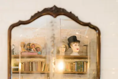 a display case with mannequins and books on a shelf at Pars Teatro Hostel in Barcelona