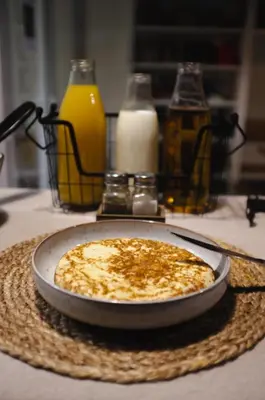 a cheese pizza on a table with bottles of milk at Pars Teatro Hostel in Barcelona