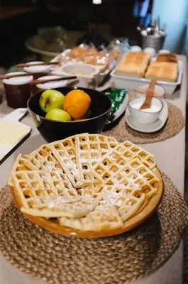 a table with a waffle and a bowl of fruit at Pars Teatro Hostel in Barcelona