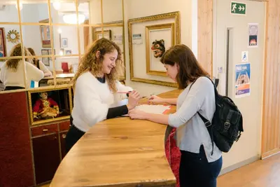 two women are standing at a counter in a salon at Pars Teatro Hostel in Barcelona
