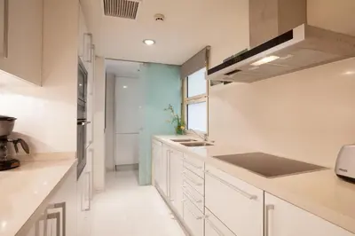 a kitchen with white cabinets and a sink at Akira Flats Plaza Catalunya Centric apartments in Barcelona