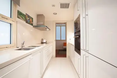 a kitchen with white cabinets and a sink at Akira Flats Plaza Catalunya Centric apartments in Barcelona