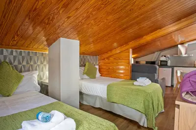 a room with two beds and a wooden ceiling at Alcam Studio Alio3 in Barcelona