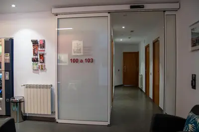 a glass door with a sign that reads at Hostal Apolo in Barcelona