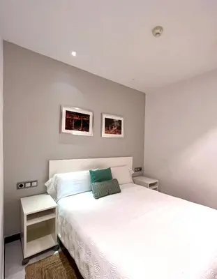 a bedroom with a white bed with two night stands at Hostal Apolo in Barcelona