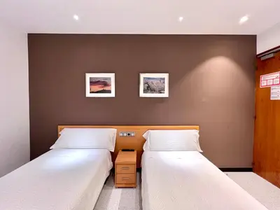 two beds in a small room with twoermottermottermott at Hostal Apolo in Barcelona