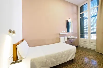 a hotel room with a bed and a sink at Pensión Peiró in Barcelona