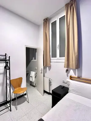 a bedroom with a bed and a chair at Pensión Peiró in Barcelona