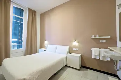 a bedroom with a white bed and a sink at Pensión Peiró in Barcelona