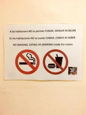 a sign on a wall that says no smoking and eating on drinking inside the room at Hostel New York in Barcelona
