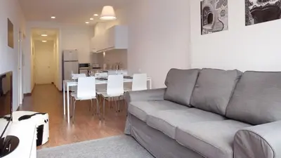 a living room with a couch and a kitchen with a table at AB Montjuic in Barcelona
