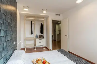 a bedroom with a bed with a tray of fruit on it at AB Montjuic in Barcelona