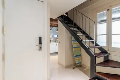 a staircase in a living room with a window at AB Poble Nou Venero in Barcelona