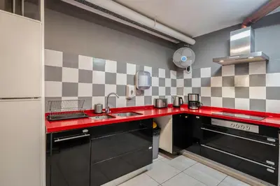a kitchen with a red counter top and a sink at Casa Barcelo Camp Nou Barcelona in Hospitalet de Llobregat